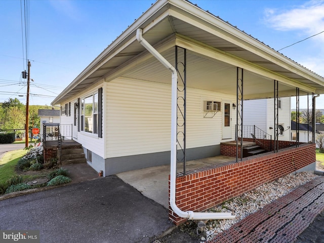 view of side of property featuring a wall mounted AC and a carport