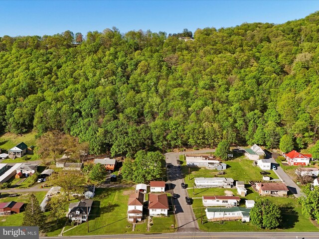 drone / aerial view featuring a forest view and a residential view