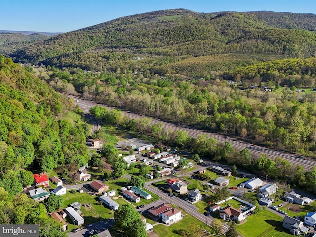 birds eye view of property with a mountain view and a wooded view