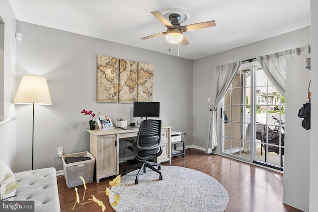 office featuring baseboards, a ceiling fan, and dark wood-style floors