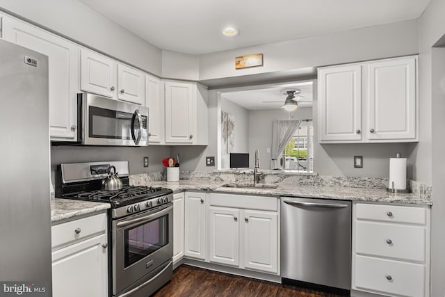 kitchen featuring ceiling fan, dark wood finished floors, a sink, stainless steel appliances, and white cabinetry