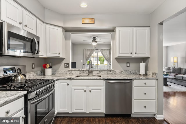 kitchen with a sink, a ceiling fan, stainless steel appliances, and dark wood-style floors