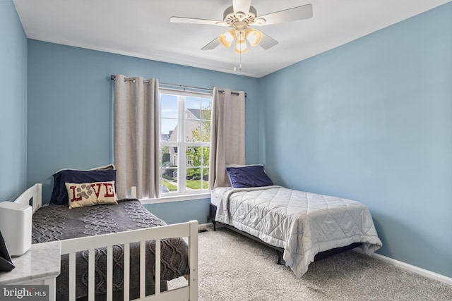bedroom with a ceiling fan, baseboards, and carpet