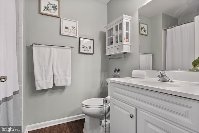 full bath with vanity, toilet, a shower with shower curtain, baseboards, and wood finished floors