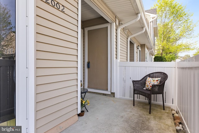 entrance to property featuring fence and a patio area