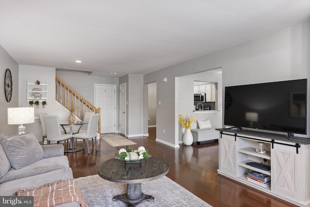 living room featuring recessed lighting, baseboards, stairway, and dark wood-type flooring