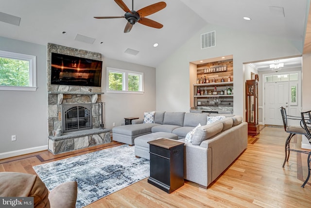 10935 Ravenwood Dr, Manassas, VA 20111 - living room with high vaulted ceiling, a stone fireplace, light wood-style flooring, a ceiling fan, and visible vents