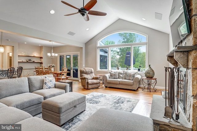10935 Ravenwood Dr, Manassas, VA 20111 - living area featuring visible vents, light wood-style floors, a stone fireplace, ceiling fan with notable chandelier, and vaulted ceiling