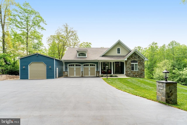 10935 Ravenwood Dr, Manassas, VA 20111 - craftsman house featuring a front lawn, aphalt driveway, stone siding, roof with shingles, and a porch