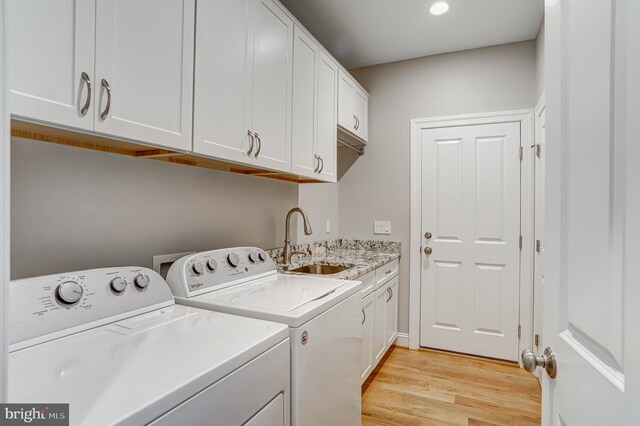 10935 Ravenwood Dr, Manassas, VA 20111 - laundry area with a sink, cabinet space, washing machine and dryer, and light wood-style flooring
