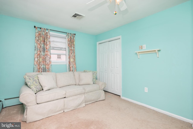 carpeted living room featuring baseboard heating, ceiling fan, visible vents, and baseboards