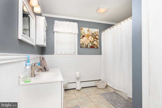 bathroom featuring crown molding, baseboard heating, and wainscoting