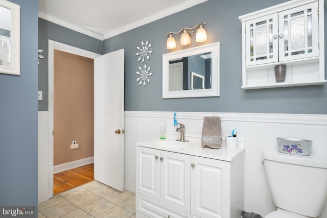 bathroom with crown molding, a wainscoted wall, vanity, and tile patterned floors