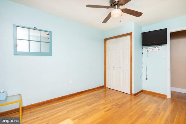 unfurnished bedroom with baseboards, light wood finished floors, ceiling fan, and a closet