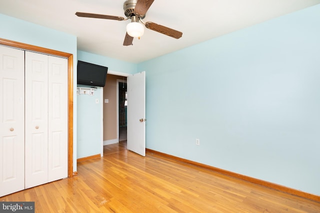unfurnished bedroom featuring a closet, baseboards, a ceiling fan, and light wood-type flooring