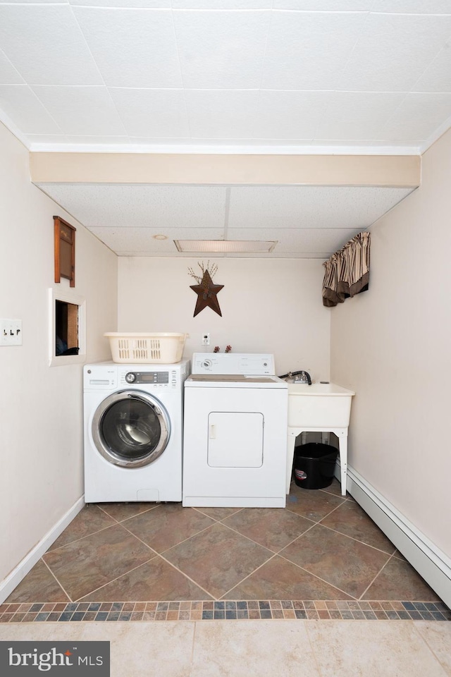 washroom with baseboards, laundry area, a baseboard heating unit, and washing machine and clothes dryer