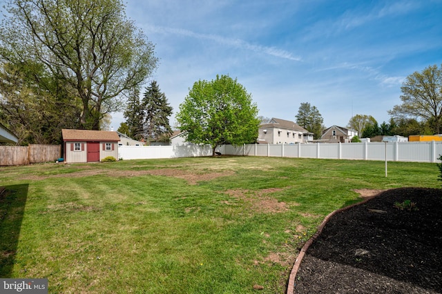 view of yard featuring an outdoor structure, a fenced backyard, and a shed