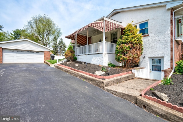 view of front of home featuring an outdoor structure, a garage, and stucco siding