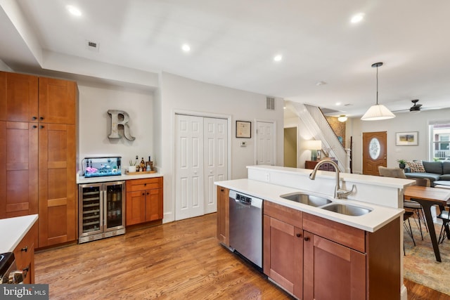 kitchen featuring stainless steel dishwasher, light countertops, a sink, open floor plan, and wine cooler