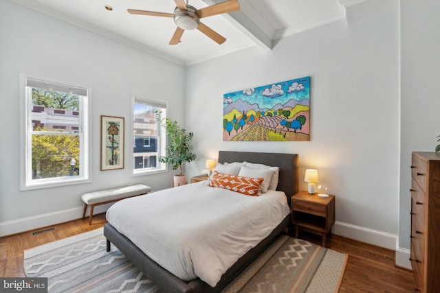 bedroom with crown molding, baseboards, visible vents, and wood finished floors