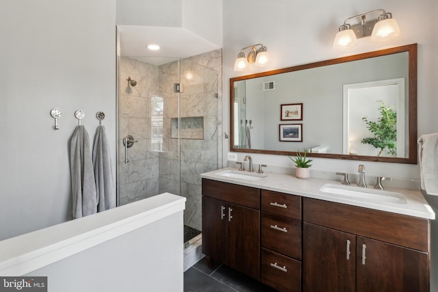 bathroom with a sink, a tile shower, double vanity, and visible vents