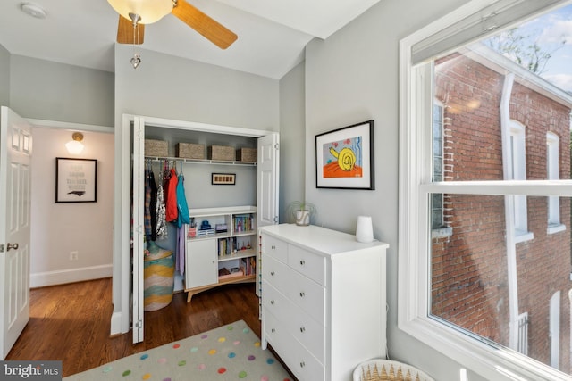 bedroom with baseboards, a ceiling fan, a closet, and wood finished floors