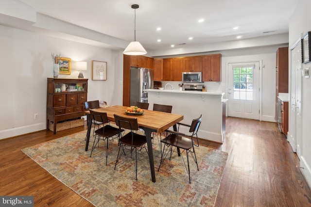 dining space featuring baseboards, recessed lighting, and wood finished floors
