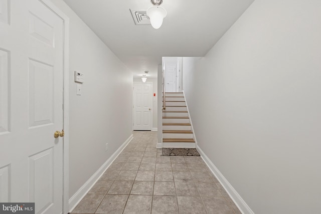 hall with stairs, light tile patterned flooring, baseboards, and visible vents