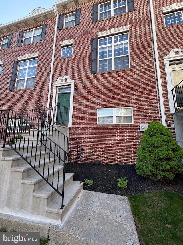 entrance to property featuring brick siding