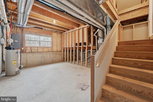basement featuring electric panel, gas water heater, and stairs