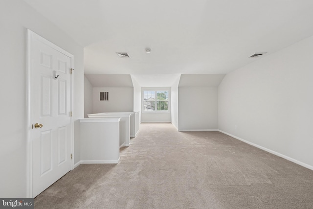additional living space with lofted ceiling, carpet, baseboards, and visible vents