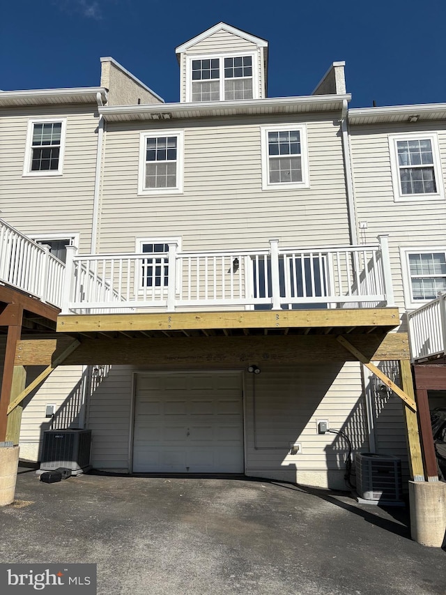 back of house featuring central AC unit, stairs, and a garage