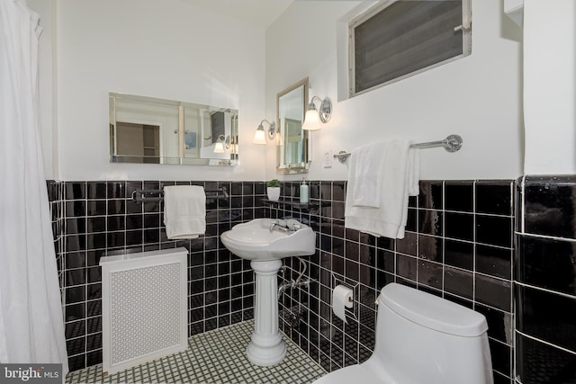 4000 Cathedral Ave NW Unit 435-436-437B, Washington, DC 20016 - bathroom with radiator, tile walls, toilet, wainscoting, and tile patterned flooring