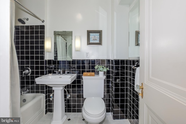4000 Cathedral Ave NW Unit 435-436-437B, Washington, DC 20016 - full bathroom with tile walls, toilet,  shower combination, a wainscoted wall, and a sink