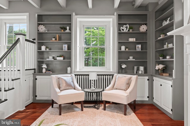 sitting room with radiator heating unit, plenty of natural light, dark wood-type flooring, and beam ceiling