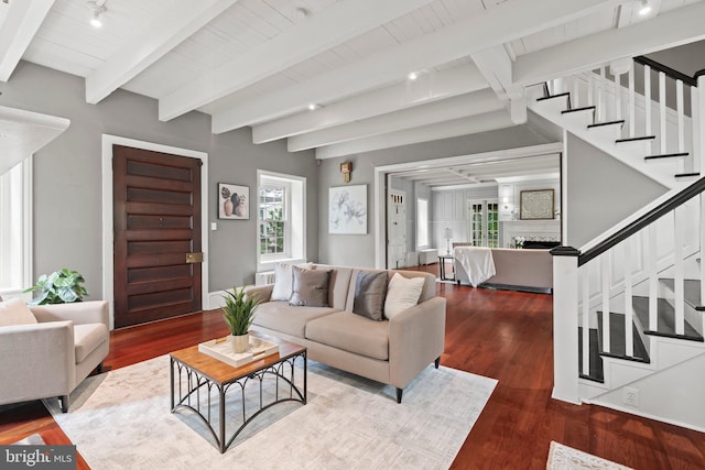 living area featuring stairs, wood finished floors, a fireplace, beam ceiling, and wooden ceiling