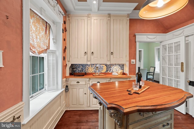 kitchen with butcher block counters, dark wood-style floors, tasteful backsplash, beamed ceiling, and ornamental molding