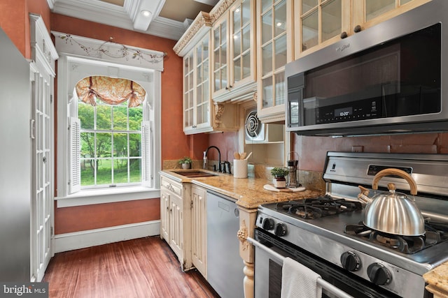 kitchen with stainless steel appliances, a sink, baseboards, wood finished floors, and glass insert cabinets