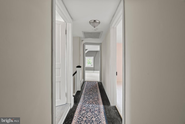 corridor featuring baseboards and inlaid floor details