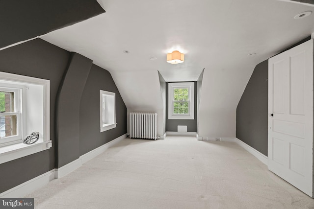bonus room featuring radiator heating unit, baseboards, carpet, and lofted ceiling
