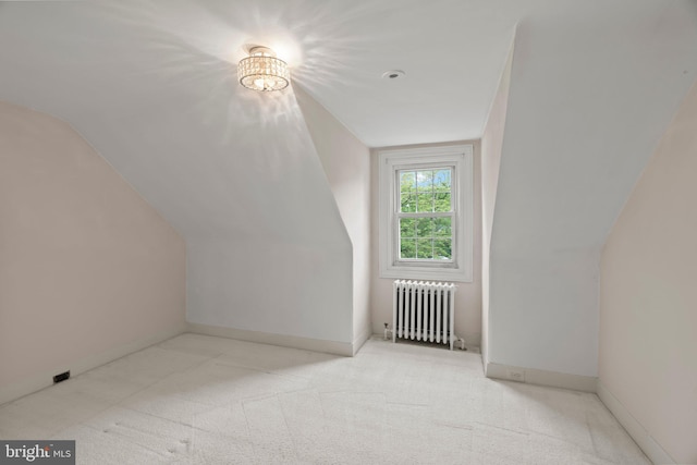 additional living space featuring radiator, carpet floors, vaulted ceiling, and baseboards