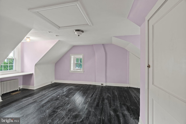 bonus room featuring radiator, vaulted ceiling, plenty of natural light, wood finished floors, and baseboards