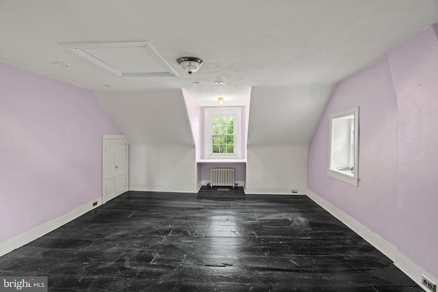 bonus room featuring radiator heating unit, lofted ceiling, baseboards, and hardwood / wood-style flooring