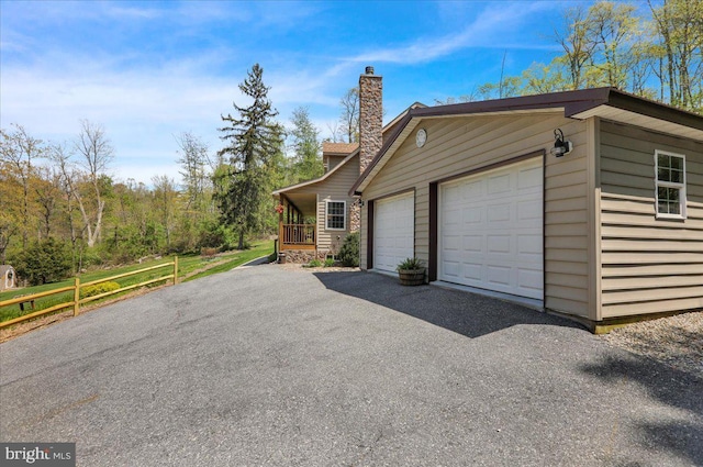 view of side of home with a chimney and a garage