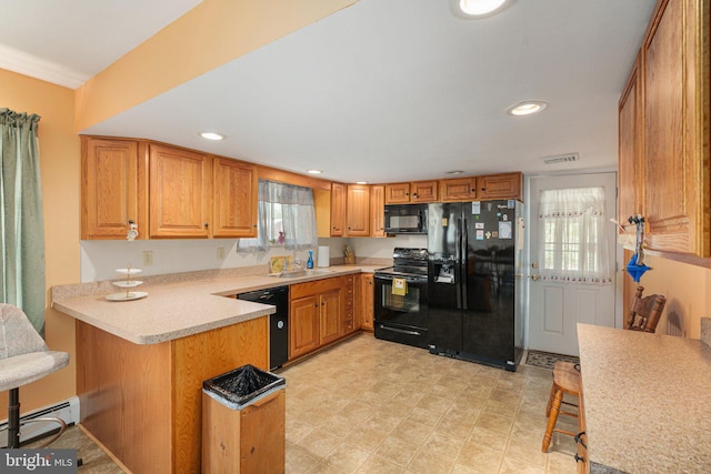 304 Snyder Rd, Reading, PA 19605 - kitchen with black appliances, a peninsula, light countertops, a sink, and recessed lighting