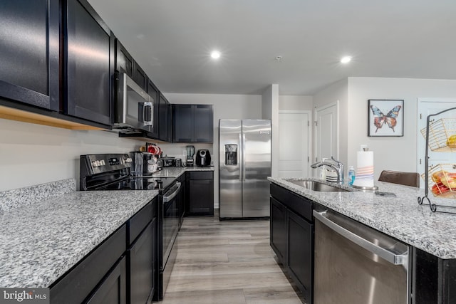 102 Magnolia Dr, Elkton, MD 21921 - kitchen featuring light stone countertops, a sink, dark cabinets, an island with sink, and stainless steel appliances