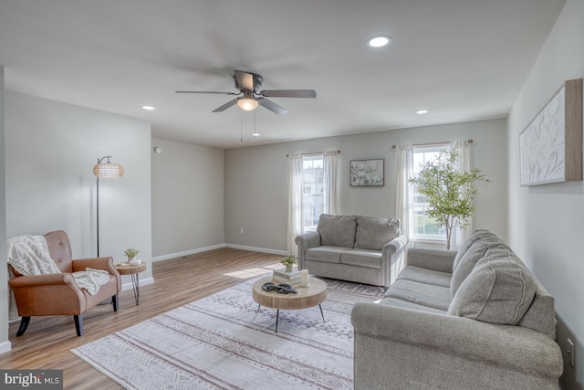 living room with a ceiling fan, baseboards, recessed lighting, and light wood-type flooring