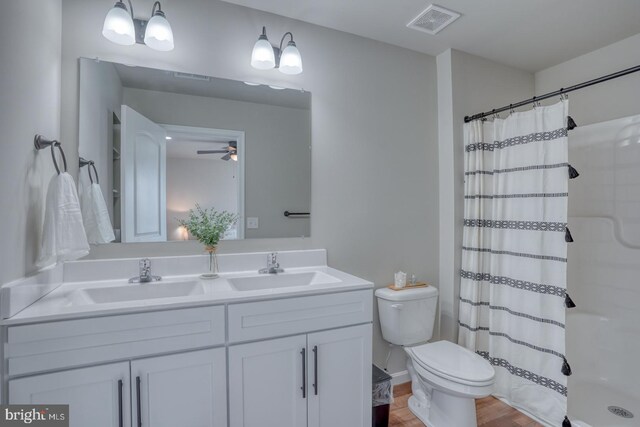 bathroom with double vanity, visible vents, curtained shower, a sink, and toilet