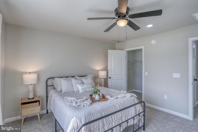 carpeted bedroom with a walk in closet, ceiling fan, baseboards, a closet, and recessed lighting