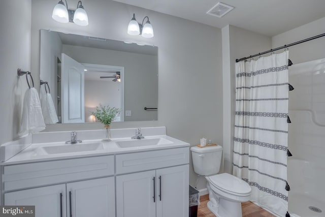 bathroom with double vanity, visible vents, curtained shower, a sink, and toilet